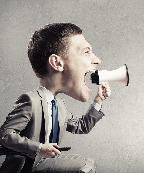 Funny young man with big head screaming emotionally in megaphone